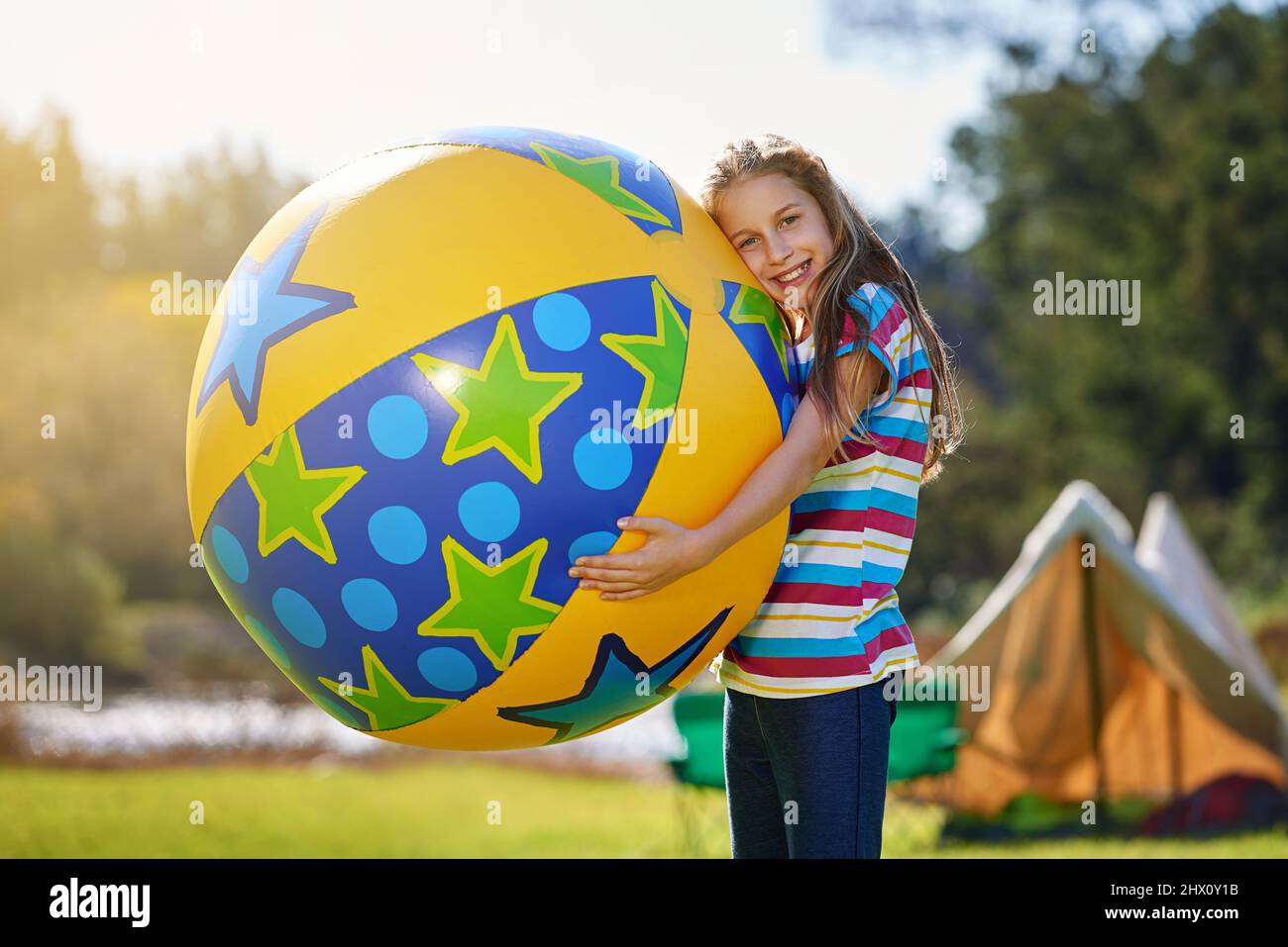 Je suis un ballon cet été. Portrait d'une adolescente tenant un énorme ballon gonflable à l'extérieur. Banque D'Images