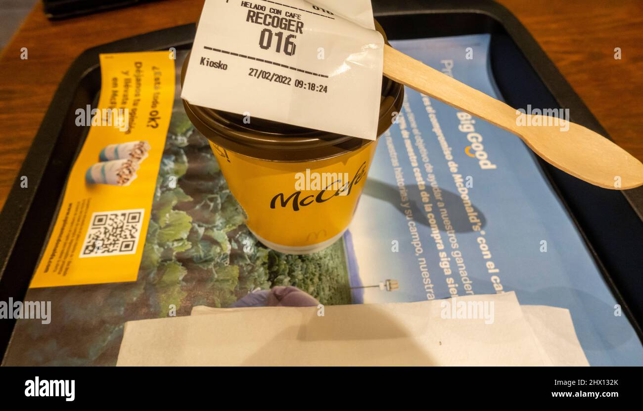 Café americano dans une tasse de papier plateau avec un mélange de bois sur une table dans le café McDonalds à l'aéroport de Madrid, Espagne Banque D'Images