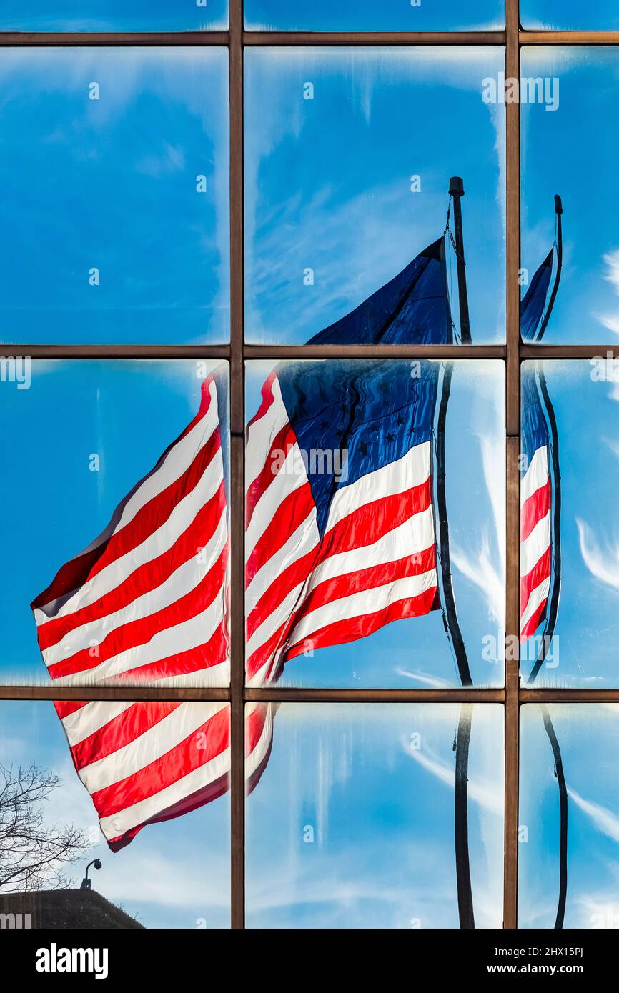 Drapeau américain volant dans le vent, fracturé dans ses réflexions dans les fenêtres en verre d'un bâtiment moderne, Michigan, États-Unis Banque D'Images