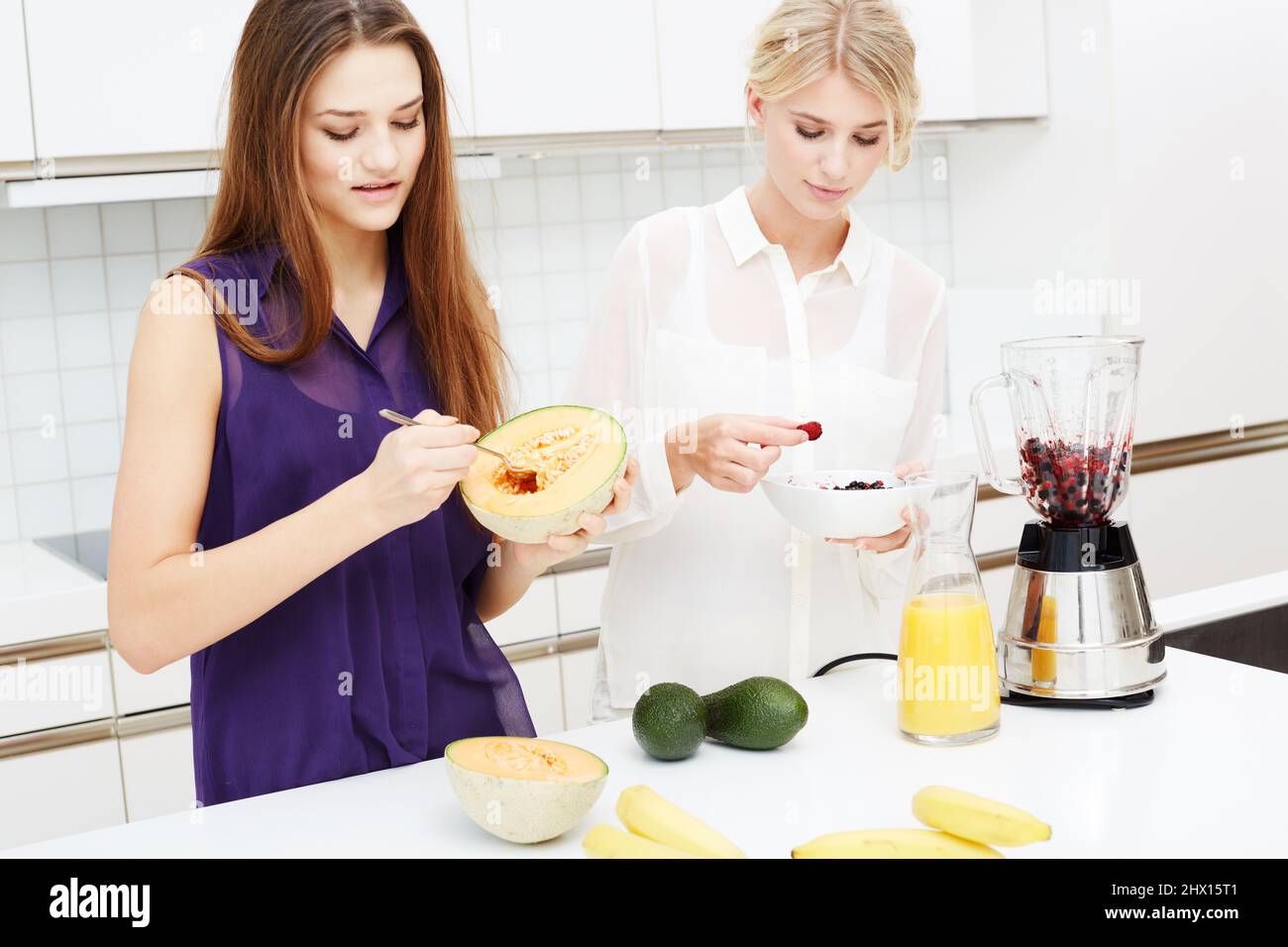 Être en bonne santé ensemble. Deux amis qui font des cocktails dans la cuisine. Banque D'Images