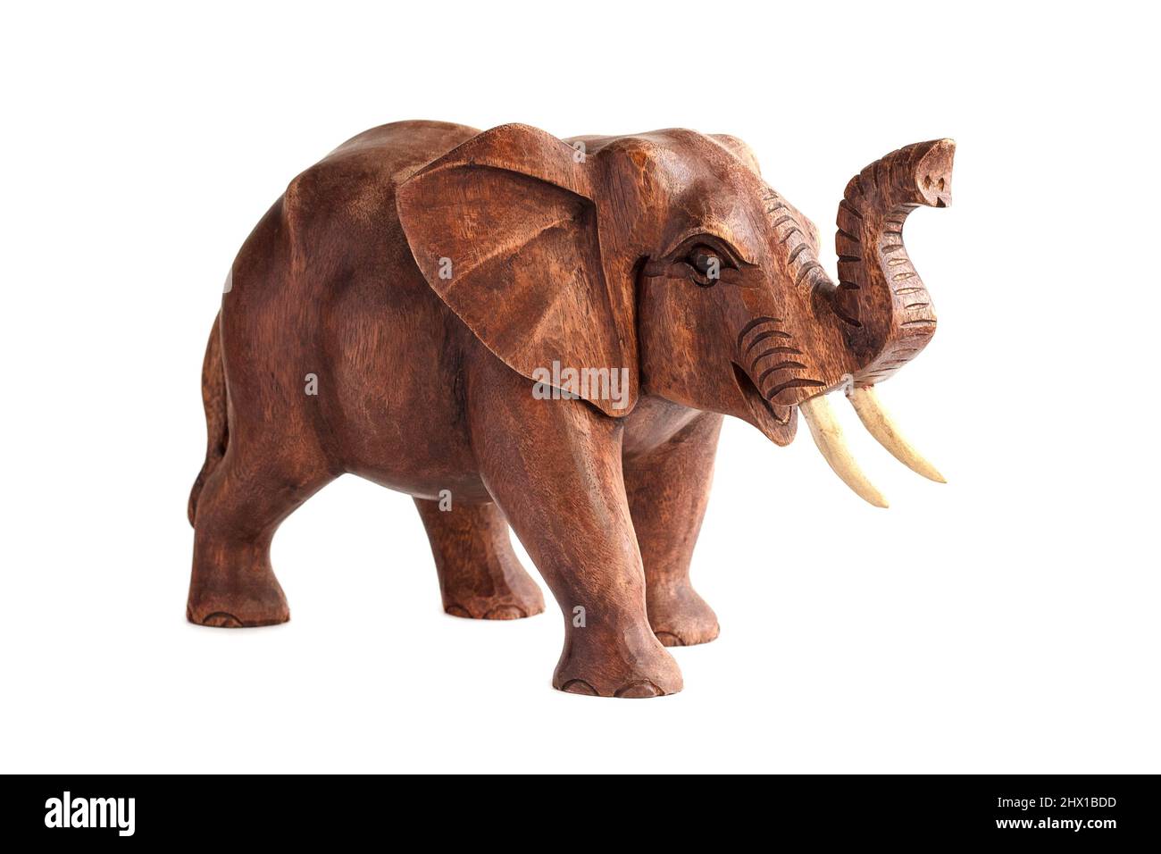 Figure en bois sculpté d'un éléphant avec un tronc élevé au sommet. Isolé sur fond blanc Banque D'Images