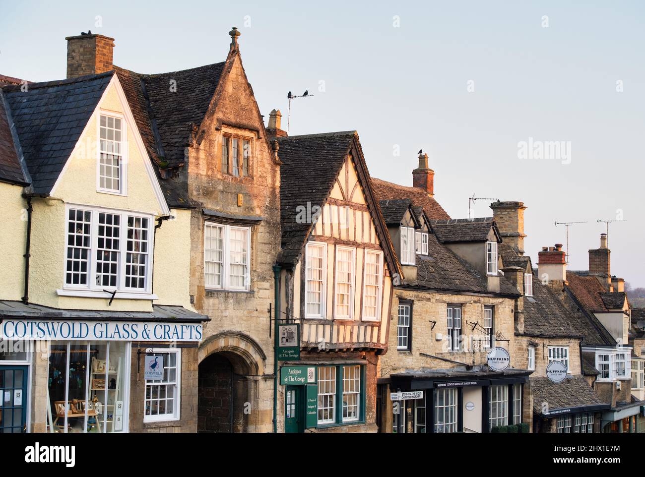 L'époque de Burford High Street abrite des fenêtres et des toits en mars au lever du soleil. Burford, Cotswolds, Oxfordshire, Angleterre Banque D'Images