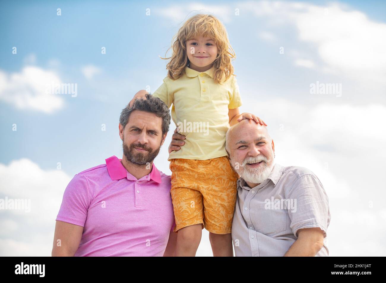 Portrait de grand-père père père et son drôle enfant à l'extérieur sur le ciel. Fête des pères. Hommes de différents âges. Famille multi-génération. Banque D'Images