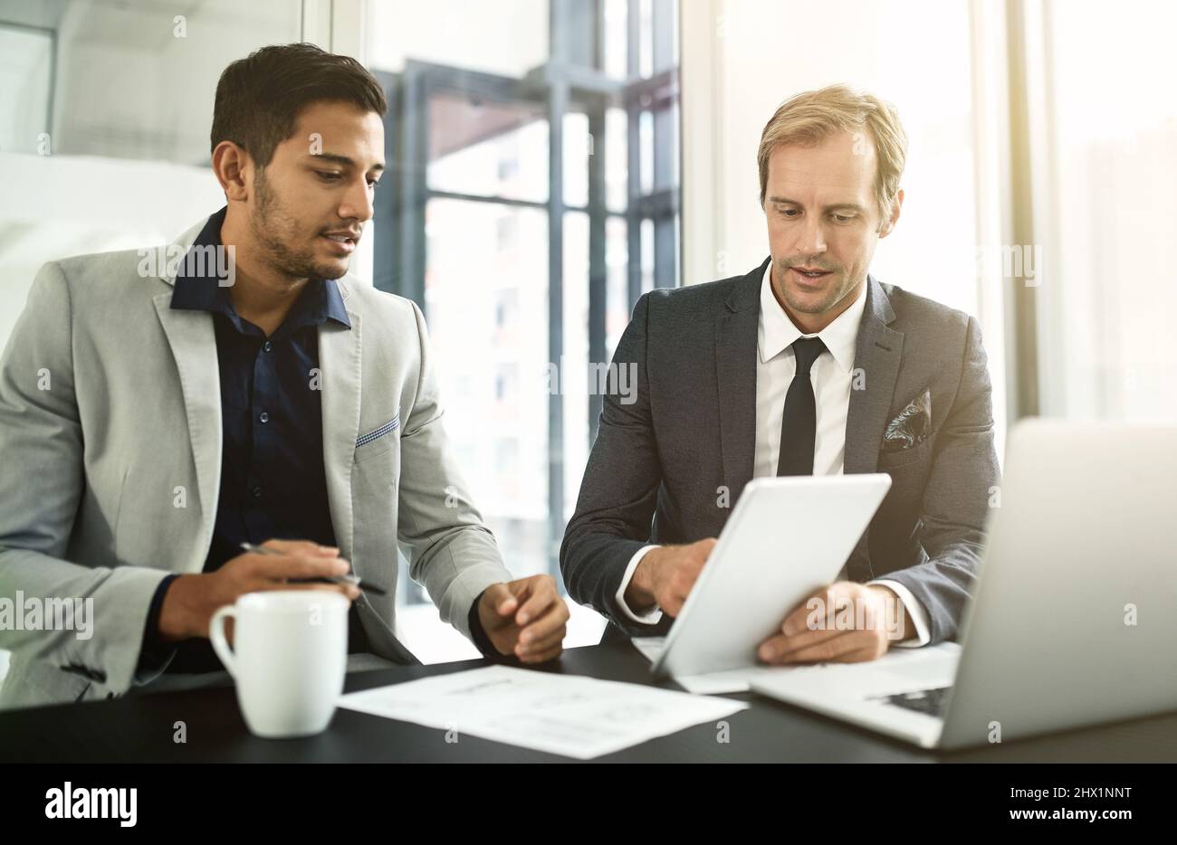 La technologie leur permet d'atteindre de nouveaux marchés économiques. Photo de deux hommes d'affaires ayant une discussion dans un bureau. Banque D'Images