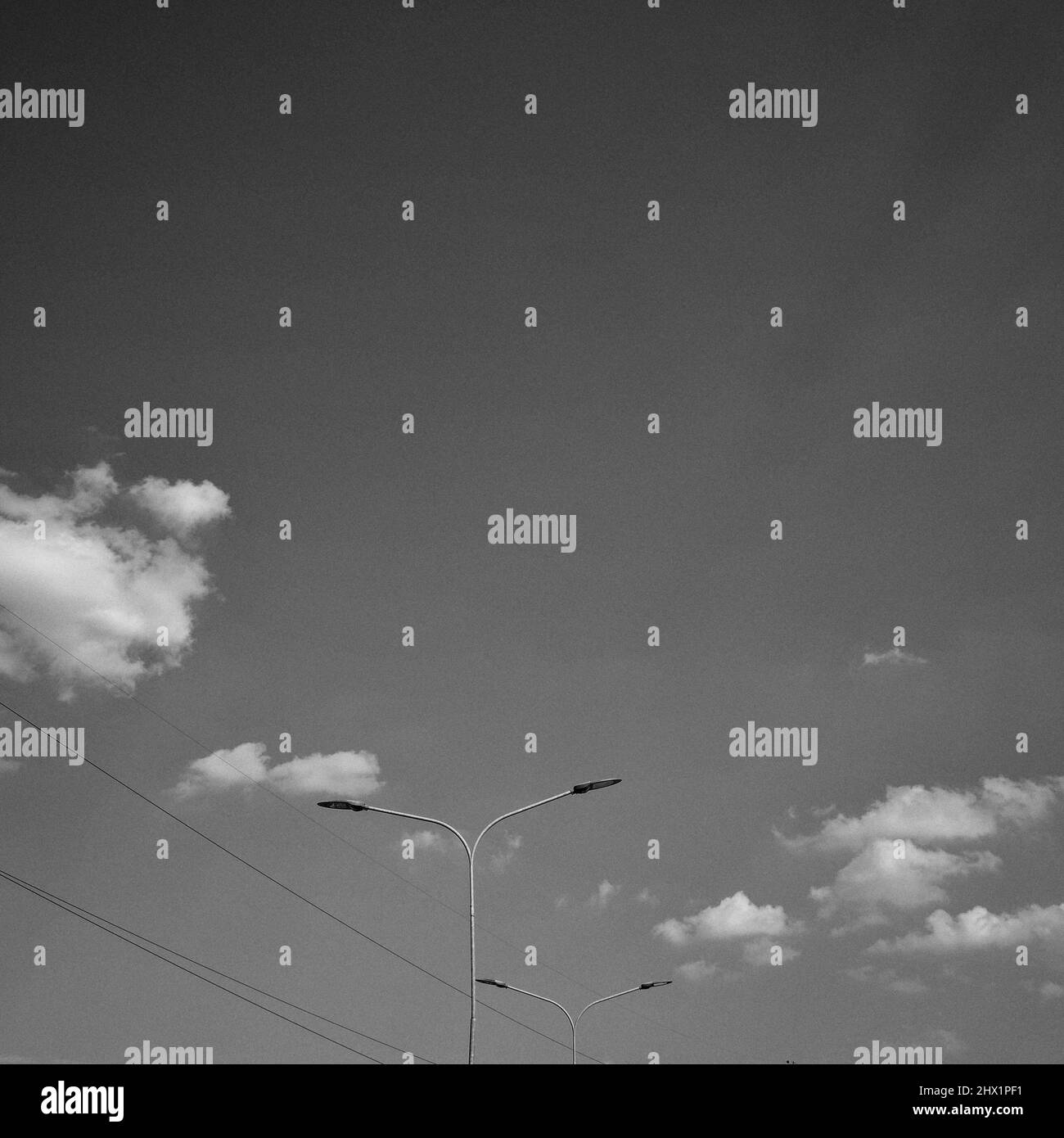 Feux de rue à haute tension dans un ciel nuageux dramatique - Photographie d'art noir et blanc Banque D'Images
