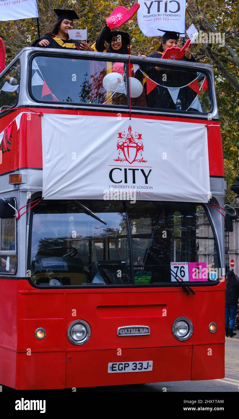 Bus londonien à impériale sans toit rouge avec City, bannières et étudiants de l'Université de Londres et personnel en tête du Lord Mayor’s Show 2021. Banque D'Images