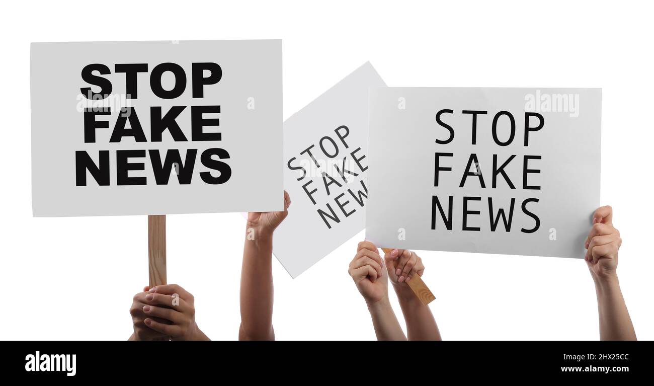 Les mains de protestataires tenant des pancartes avec du texte EMPÊCHENT LES FAUSSES NOUVELLES sur fond blanc Banque D'Images