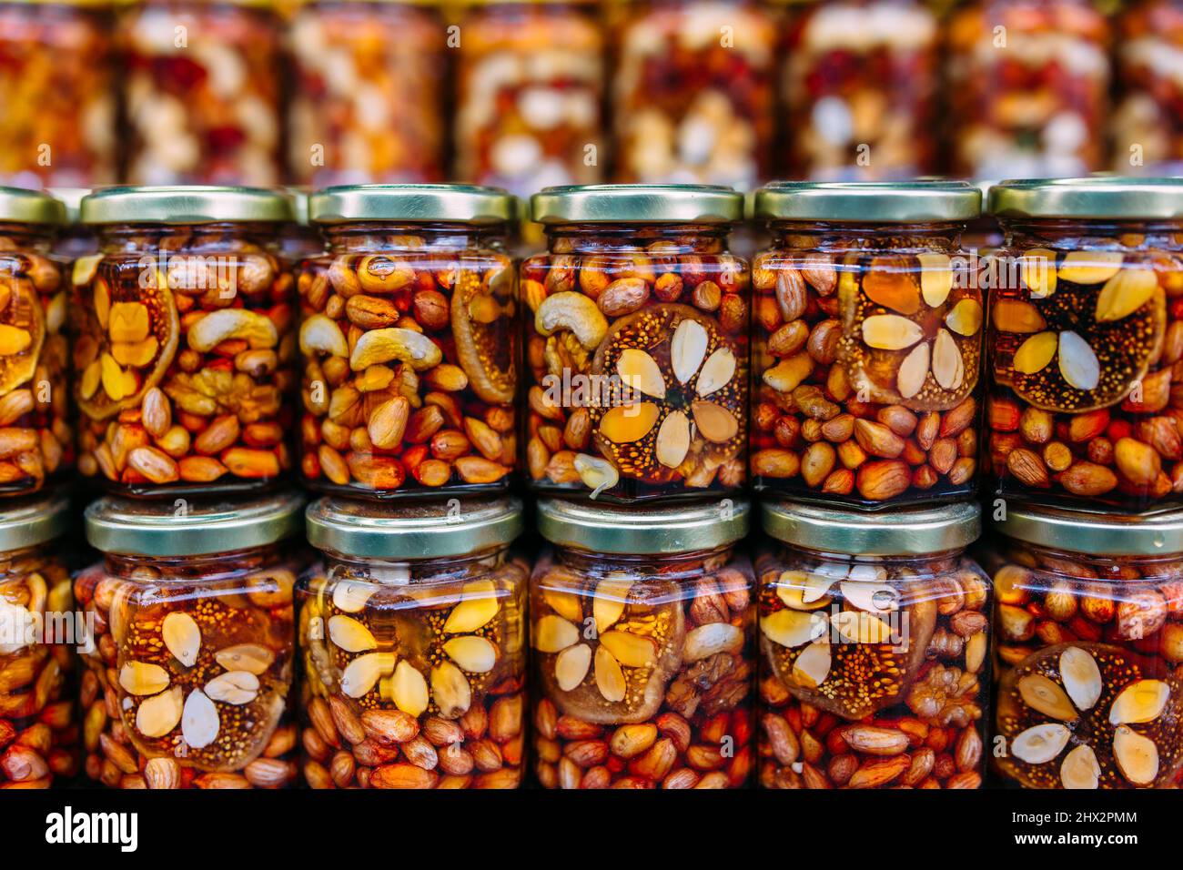 abeille avec des noix dans des boîtes de verre sur le comptoir du marché Banque D'Images