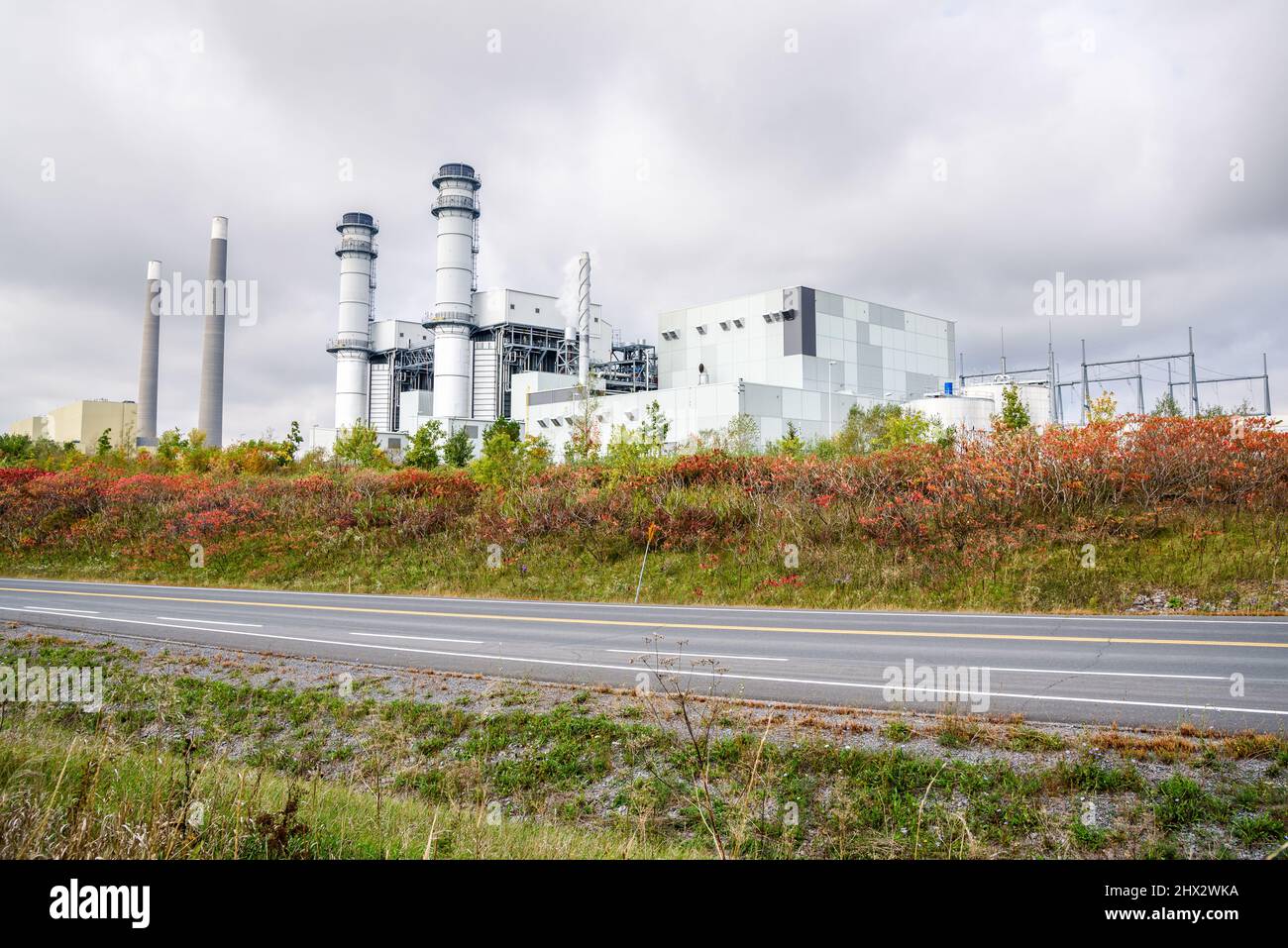 Vue sur une centrale électrique au gaz naturel le long d'une route par une journée d'automne nuageux Banque D'Images