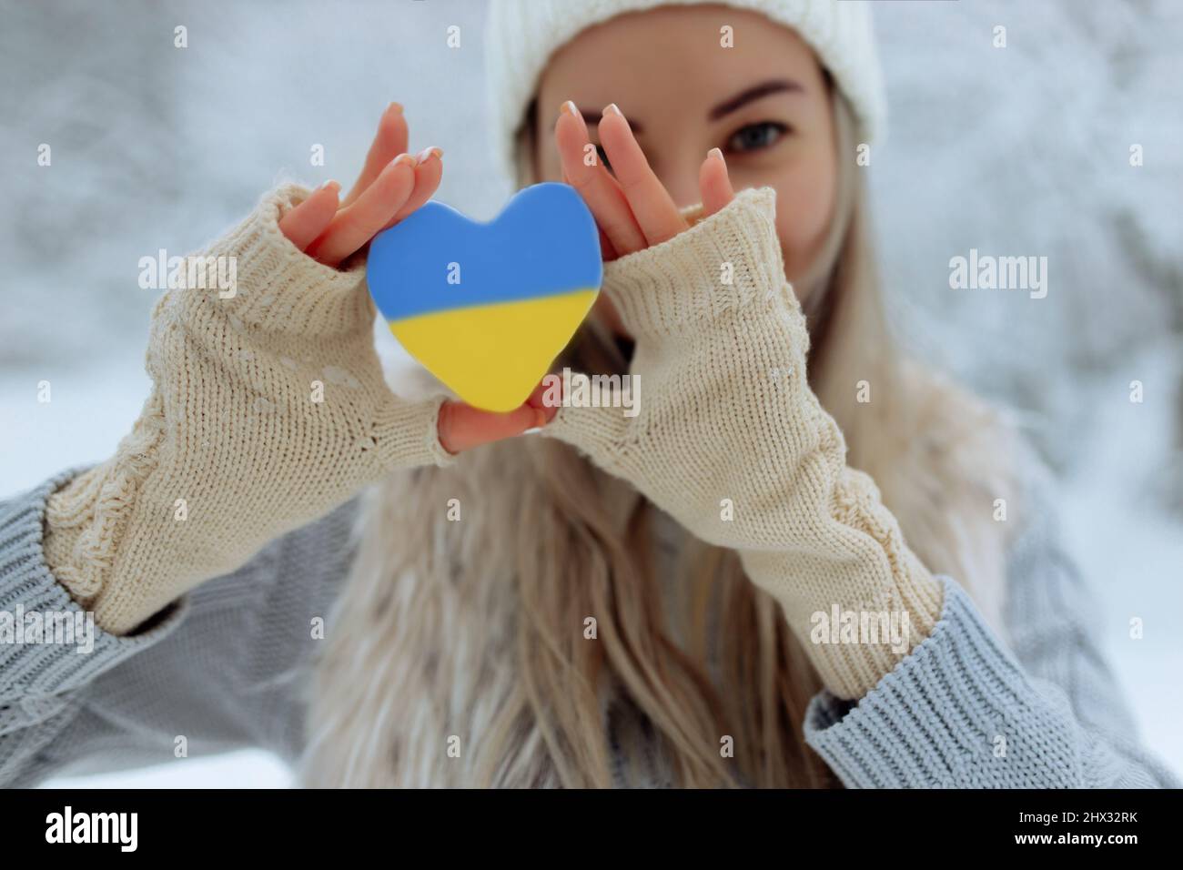 Pas de guerre. Février le début de la guerre en Ukraine la jeune fille tient un coeur d'une couleur bleue pathétique dans ses mains. La paix en Ukraine Banque D'Images