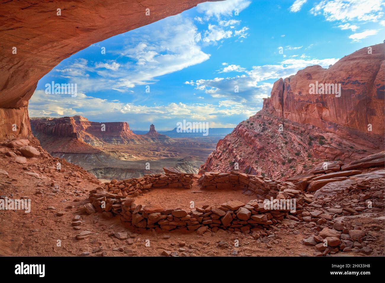 Le False Kiva ruine dans une alcôve dans le parc national de Canyonlands près de Moab, Utah. Au loin se trouve la Tour Candlestick, un monolithe de grès de l'aile Banque D'Images