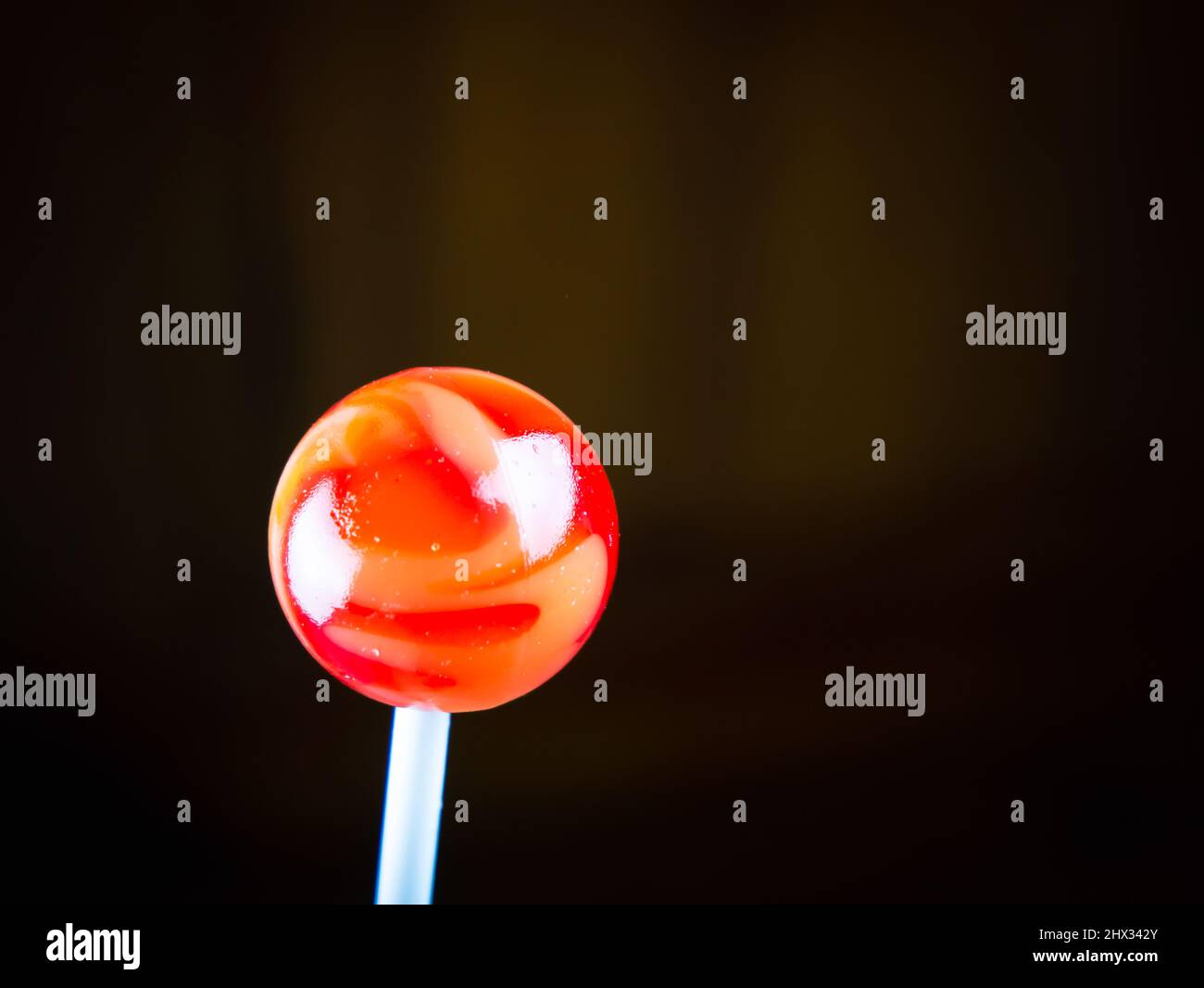 Bonbon rond rouge au caramel sur un bâton Banque D'Images