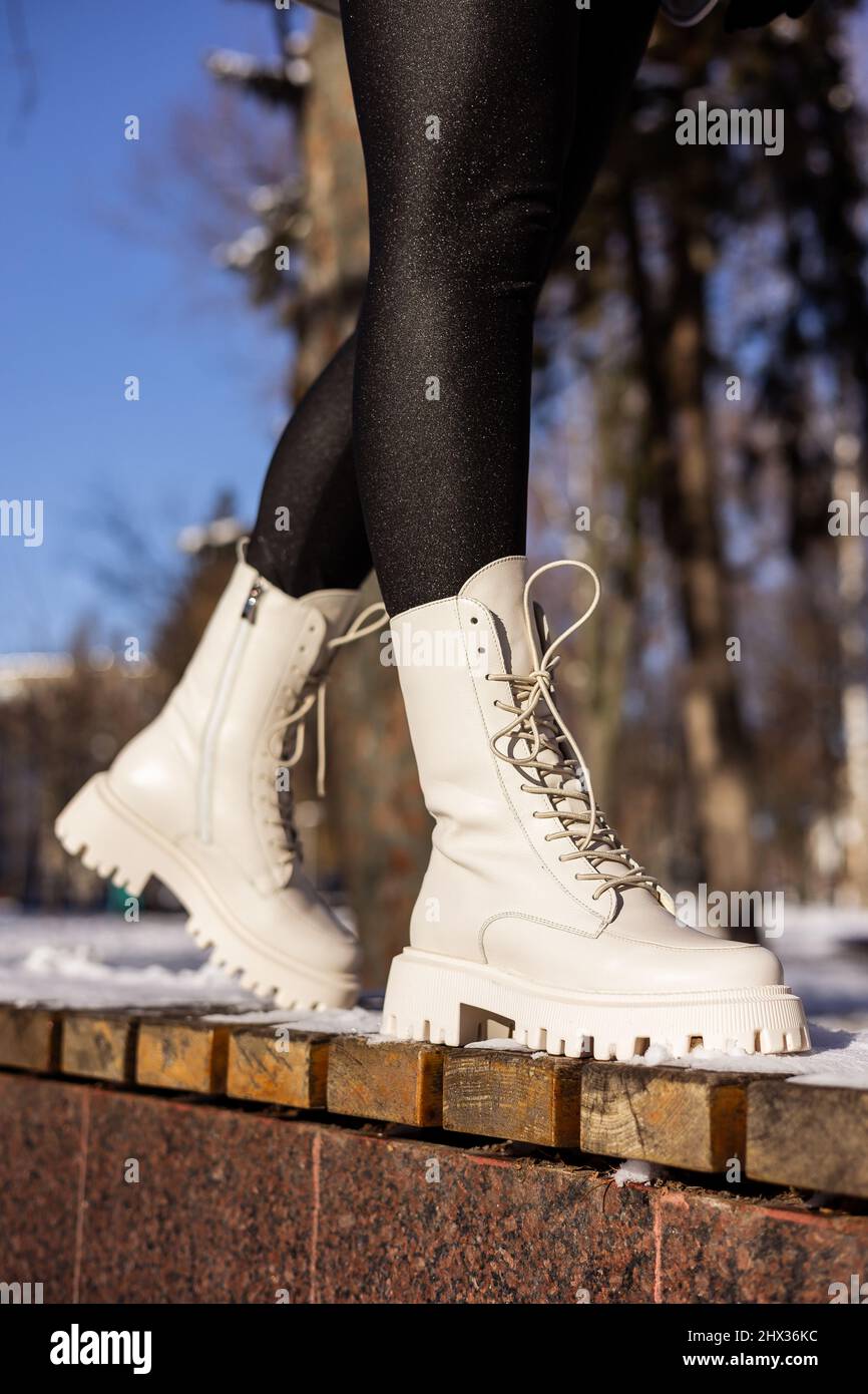 Femme en bottes blanches tendance sur neige blanche, gros plan. Jambes pour  Femme dans des bottes en cuir d'hiver élégantes Photo Stock - Alamy