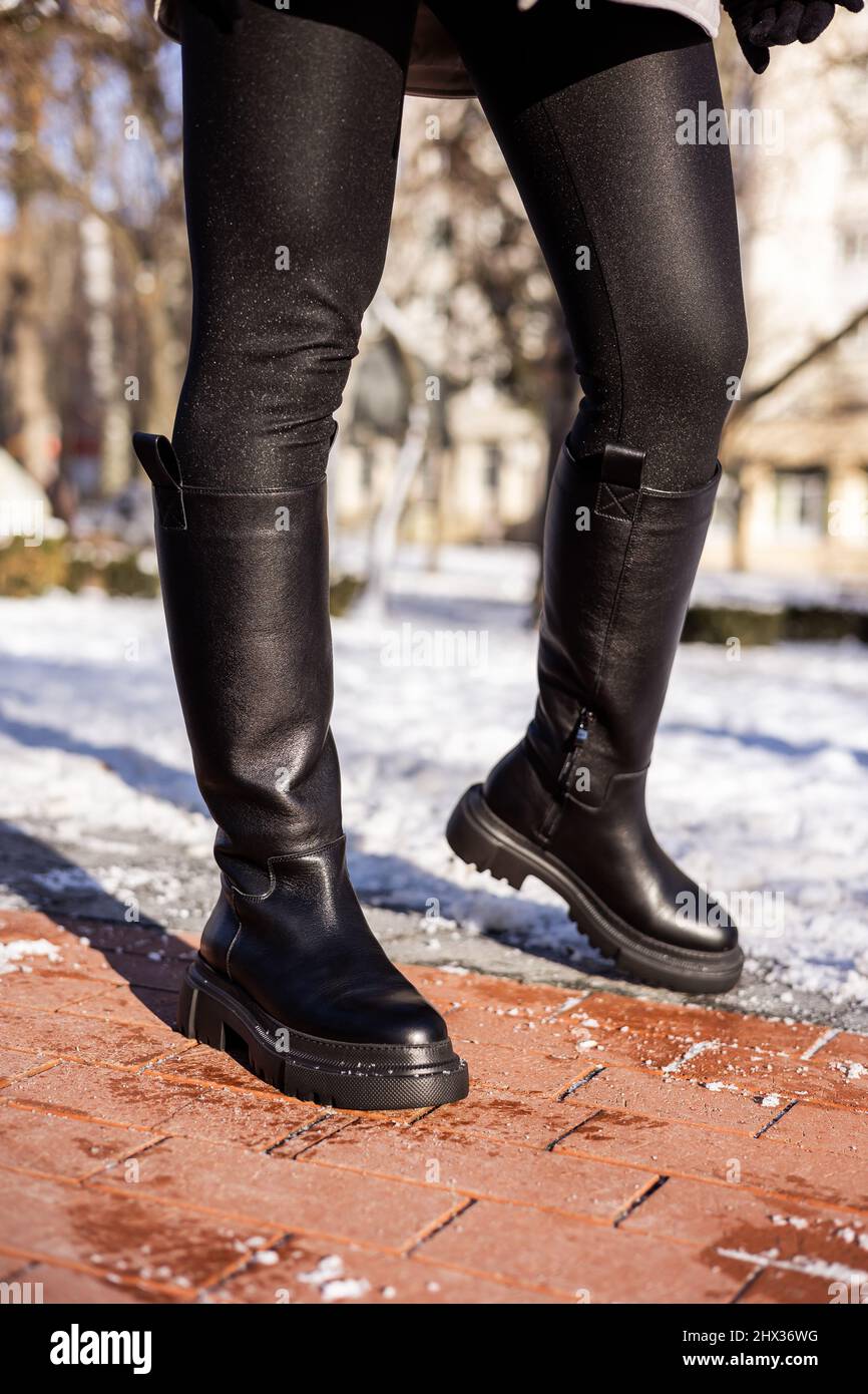 Femme en bottes noires tendance sur neige blanche, gros plan. Jambes pour  Femme dans des bottes en cuir d'hiver élégantes Photo Stock - Alamy