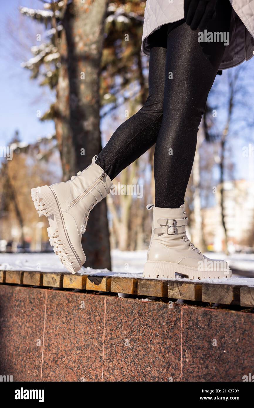 Femme en bottes blanches tendance sur neige blanche, gros plan. Jambes pour  Femme dans des bottes en cuir d'hiver élégantes Photo Stock - Alamy