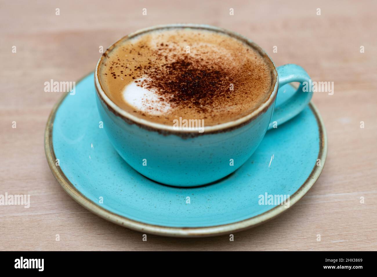 Cappuccino dans une tasse de café turquoise Banque D'Images