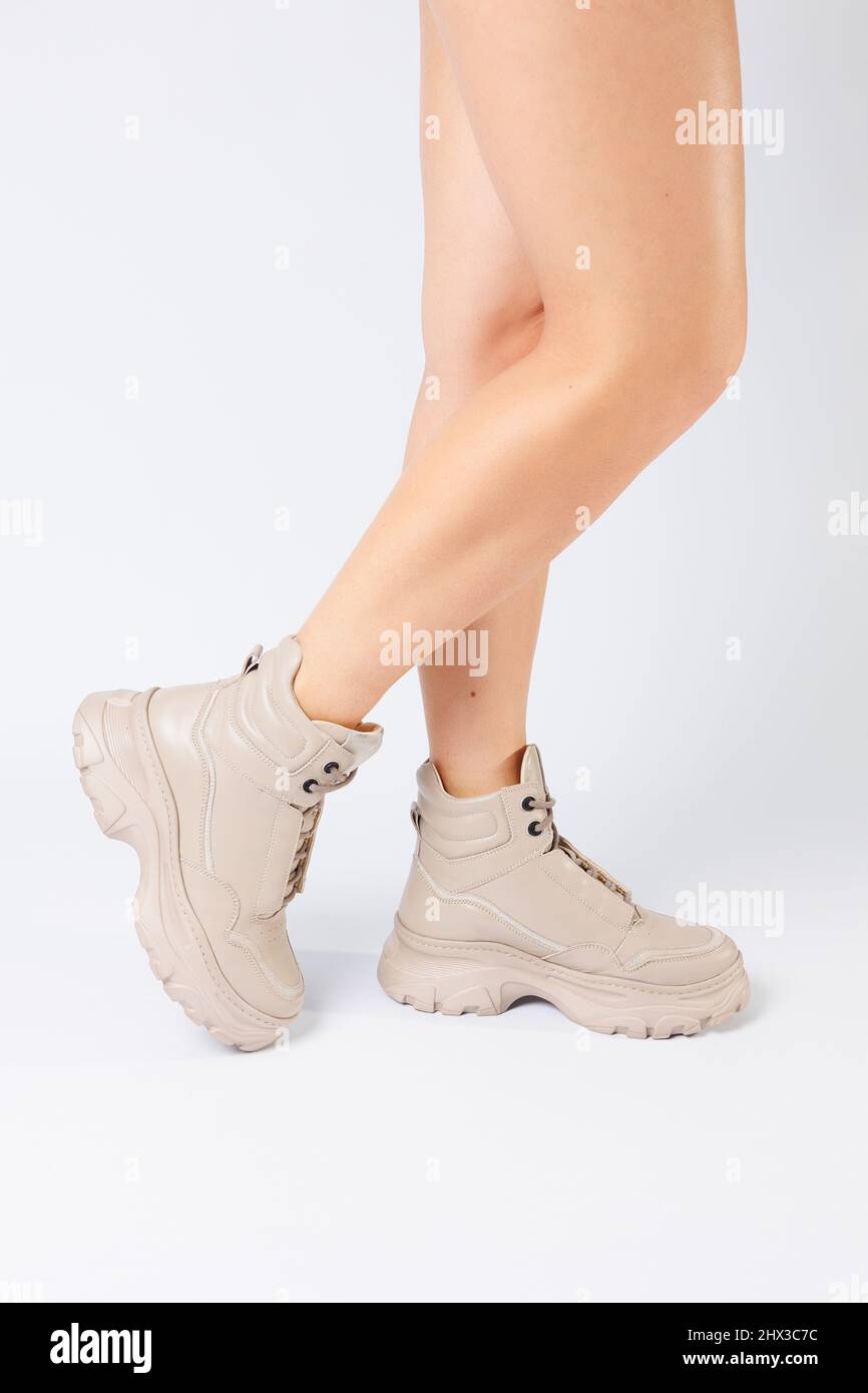 Jambes de femme en cuir beige chaussures de la nouvelle collection sur fond  blanc jambes de femme en chaussures tendance en cuir écologique printemps  2022 Photo Stock - Alamy