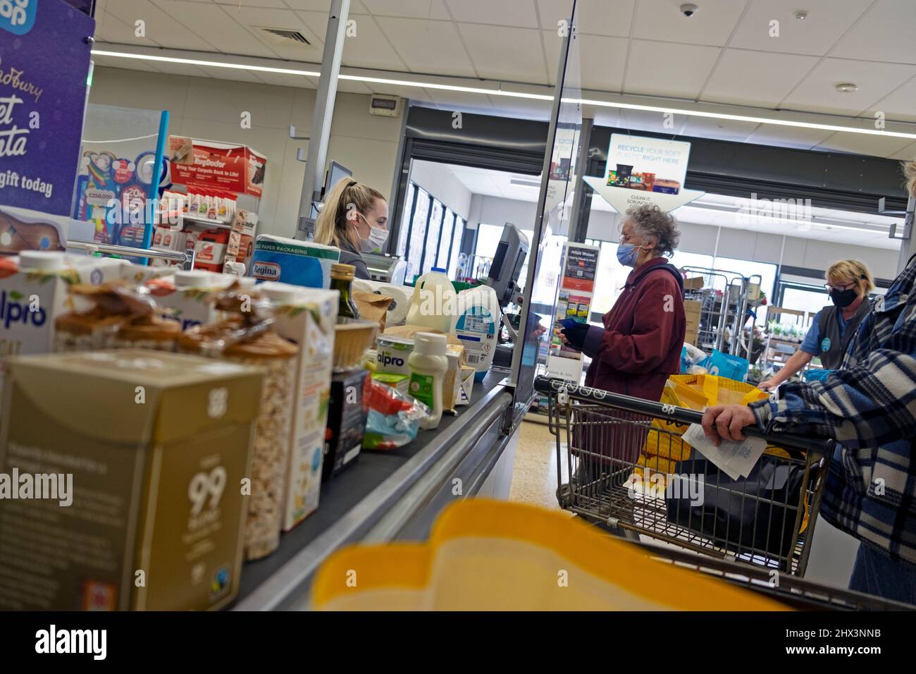 Coût de la vie nourriture épicerie au comptoir de caisse Co Op ouvrier de supermarché femme travaillant à la caisse client portant le masque Covid pays de Galles 2022 KATHY DEWITT Banque D'Images