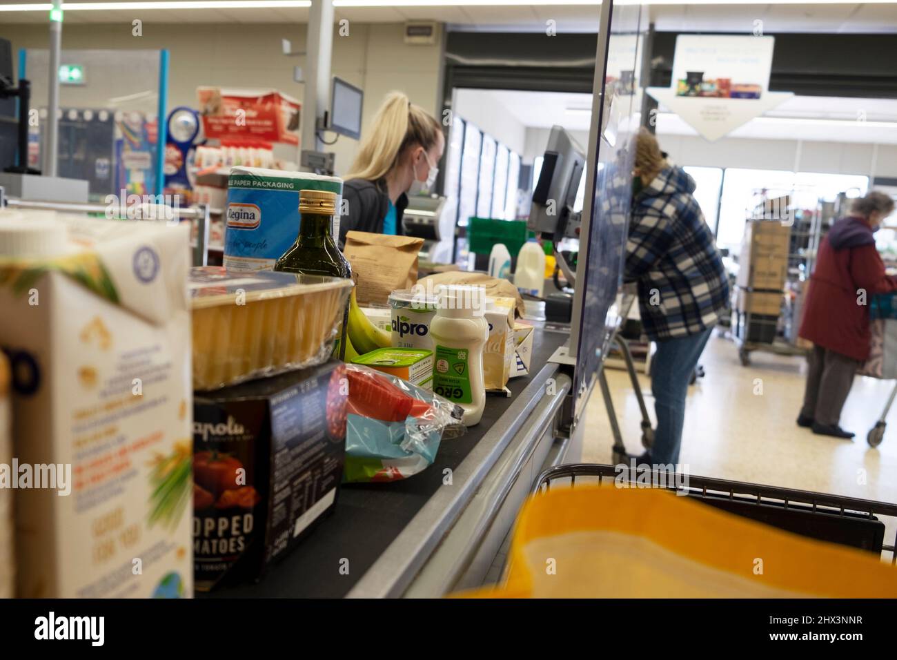 Coût de la vie nourriture épicerie au comptoir de caisse Co Op ouvrier de supermarché femme travaillant à la caisse client portant le masque Covid pays de Galles 2022 KATHY DEWITT Banque D'Images