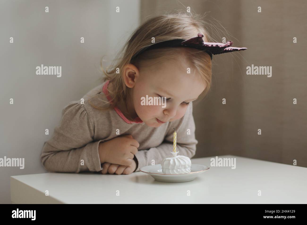 Mignon belle petite fille de bébé célébrant l'anniversaire. Enfant soufflant une bougie sur un gâteau. Fête d'anniversaire en famille pour un enfant adorable, magnifique Banque D'Images