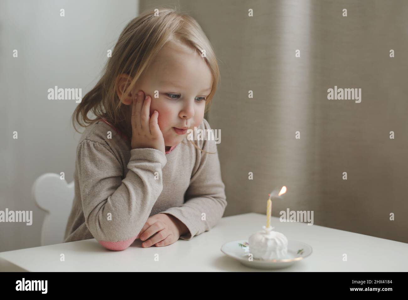 Mignon belle petite fille de bébé célébrant l'anniversaire. Enfant soufflant une bougie sur un gâteau. Fête d'anniversaire en famille pour un enfant adorable, magnifique Banque D'Images