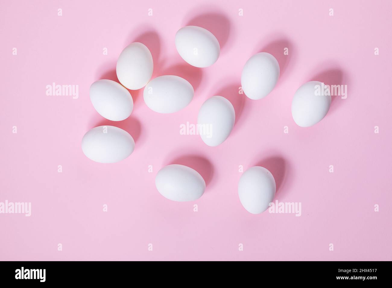 Œufs de pâques blancs sur fond rose. Vue de dessus. Différentes formes comme le lapin de pâques fait d'œufs blancs. Concept simple joyeuses Pâques Banque D'Images