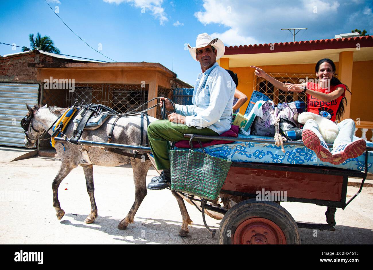 Femme assise sur un buggy tiré par des chevaux et une promenade en cow-boy cubain dans la rue de Trinidad, Cuba, un site classé au patrimoine de l'UNESCO. Banque D'Images