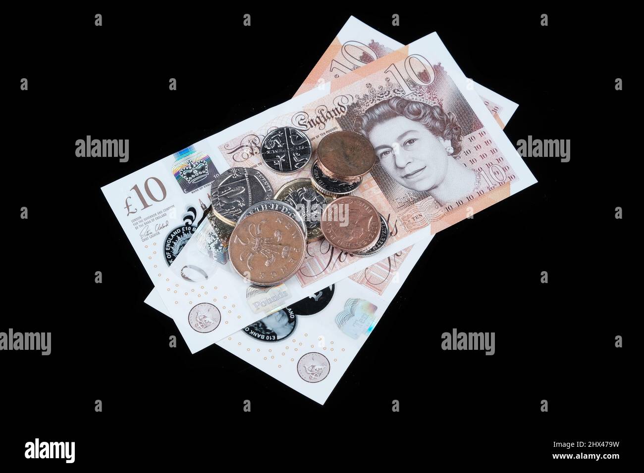 Argent britannique (espèces) sur fond noir Banque D'Images