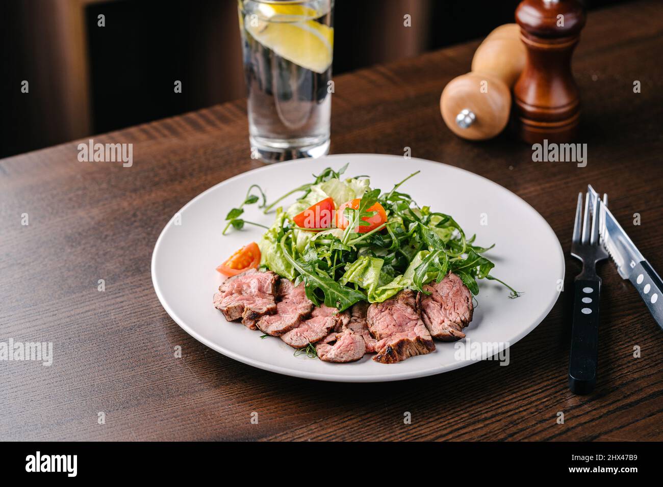 Salade avec rôti de bœuf, arugula et tomates cerises. Servir dans un café Banque D'Images