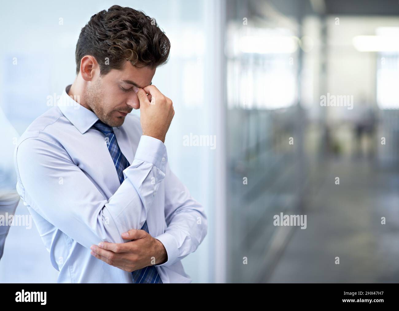 La pression est tout simplement folle. Un jeune homme d'affaires qui semble stressé au bureau. Banque D'Images