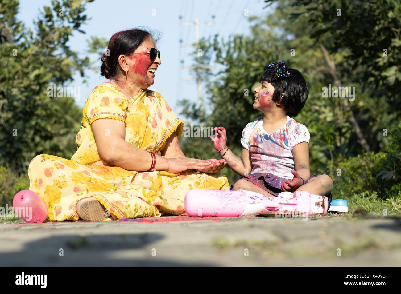 Dame et enfant indiens âgés appréciant Holi avec Gulal ou Abir Rang Abeer. Fête, famille, plaisir, fête, plaisir, Ensemble, multi-génération, Banque D'Images