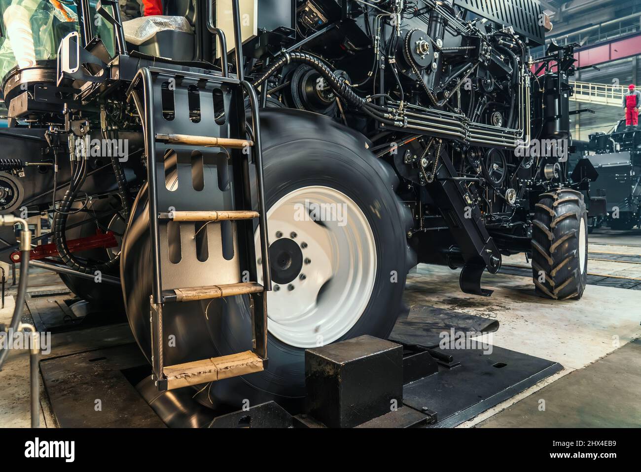 Réglage initial du tracteur agricole ou de la moissonneuse-batteuse en usine de machines industrielles. Tester et effectuer un essai de fonctionnement des roues sur un support spécial. Banque D'Images