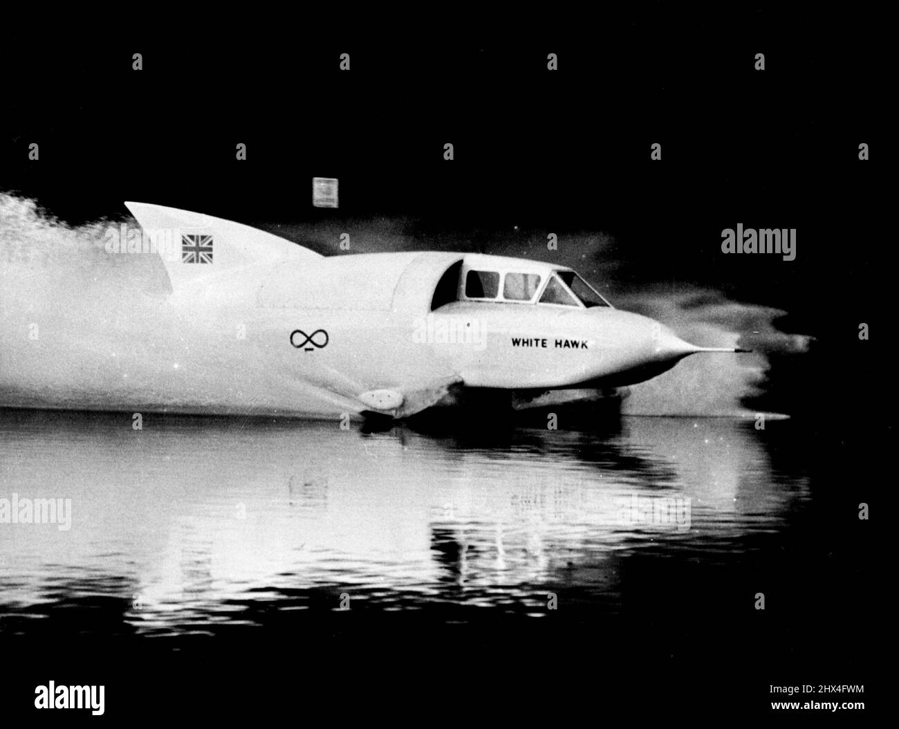 Cobb Disaster ne les dissuade pas - le hors-bord à jet « White Hawk » clignote sur les eaux du lac Windermere à plus de 100 km/h pendant une course d'essai hier, Avec Mme Stella Hanning-Lee (20) au volant. Malgré la tentative de John Cobb de battre récemment le record mondial de vitesse de l'eau sur le niveau de huard, M. et Mme Hanning-Lee se sont mis à perdre avec leur propre tentative. 9 octobre 1952. Banque D'Images