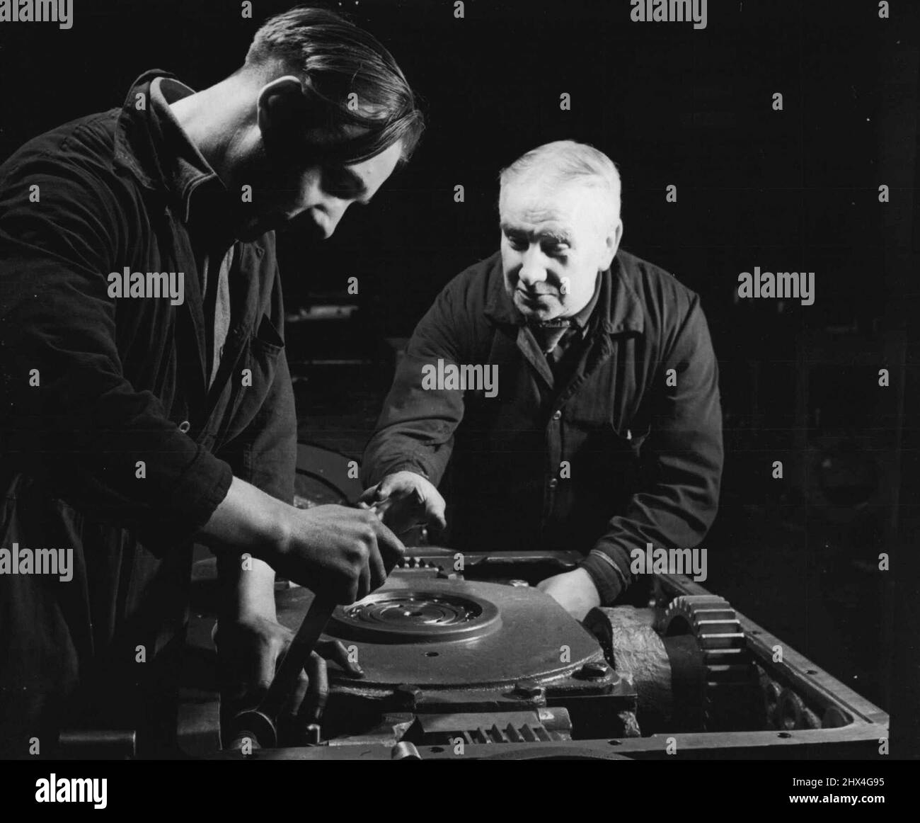 Nouvelle vie dans l'industrie lourde -- le père et son fils travaillent dans la même boutique. McMahon Senior et Junior sont des monteurs par commerce. Leur temps de service dans la boutique est de quarante et un et sept ans respectivement. Père a commencé quand il avait 14 ans à un salaire de 3/- par semaine, alors que le fils a commencé à 15 ans pour 20/ ***** une semaine. 03 septembre 1951. (Photo par British Official Photograph). Banque D'Images