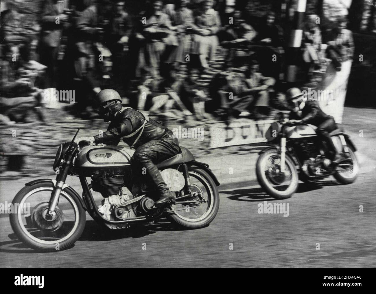 Motor Cycling 'Duke' remporte la course de l'île de Man -- Geoffrey Duke à bord d'un Norton (No.1), rattraper T. McEwen (également sur un Norton) (No 85) autour de l'angle vif au pont du gouverneur pendant la course.Geoffrey Duke - "le Duc" de course de moto - a gagné le Senior International Tourist Trophy Race dans l'île de Man hier et a écrasé tous ses propres records - par des erreurs. Sur son deuxième circuit du cours, il a mal lu un signal et a pensé qu'il mentait troisième. Il a « brûlé » les 13 derniers miles du parcours de 38 miles, touchant 130 miles perheure et a relevé son record de 93,53 miles par heure à 9 Banque D'Images