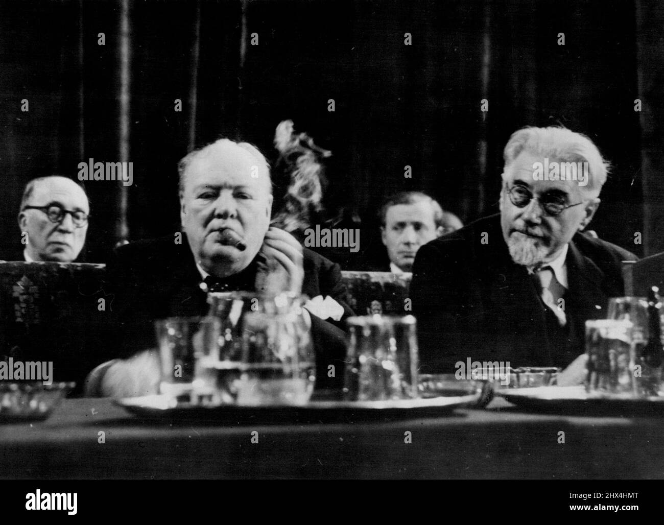 Churchill se concentre sur les Inaugurates de l'Union européenne Congrès de la Haye.The Hague - la fumée des boucles de la graisse de cigare de Winston Churchill, assis derrière la carafe à eau et les verres, Apparemment, il se concentre sur le discours qu'il devait prononcer à la réunion inaugurale du Congrès de l'Europe dans le hall des chevaliers dans la capitale néerlandaise avec lui est l'ancien premier ministre socialiste de France, M. Paul Ramadier.Churchill a été acclamé par les délégués de 23 nations, y compris les 16 dans le Plan Marshall - quand il a appelé à la création immédiate d'une Assemblée européenne et a demandé: "Hall tant de millions de Banque D'Images