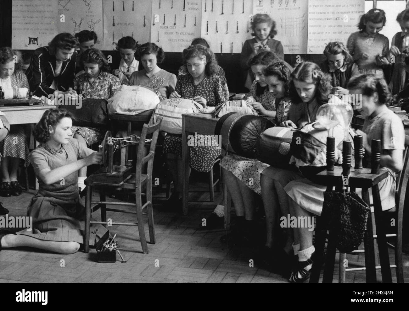 L'école ravive un vieil art. La classe de fabrication de dentelle s'est engagée dans leur tâche à l'école. Mme E. Gibson, enseignante à la New Bradwell Girls School, Wolverton, Bucks., a commencé une classe pour raviver l'art ancien de la fabrication de dentelle dans le Buckinghamshire. Partant de zéro en ce qui concerne l'équipement, elle a lancé un appel pour des bobines et des oreillers. Les habitants de la région ont répondu avec un cadeau de onze oreillers et de nombreux Bobbins, certains d'origine française, et maintenant la classe est bien en cours, certaines des filles montrant une aptitude de fortune pour les douleurs prenant la tâche. 23 mai 1949. (Photo de Fox photos). Banque D'Images