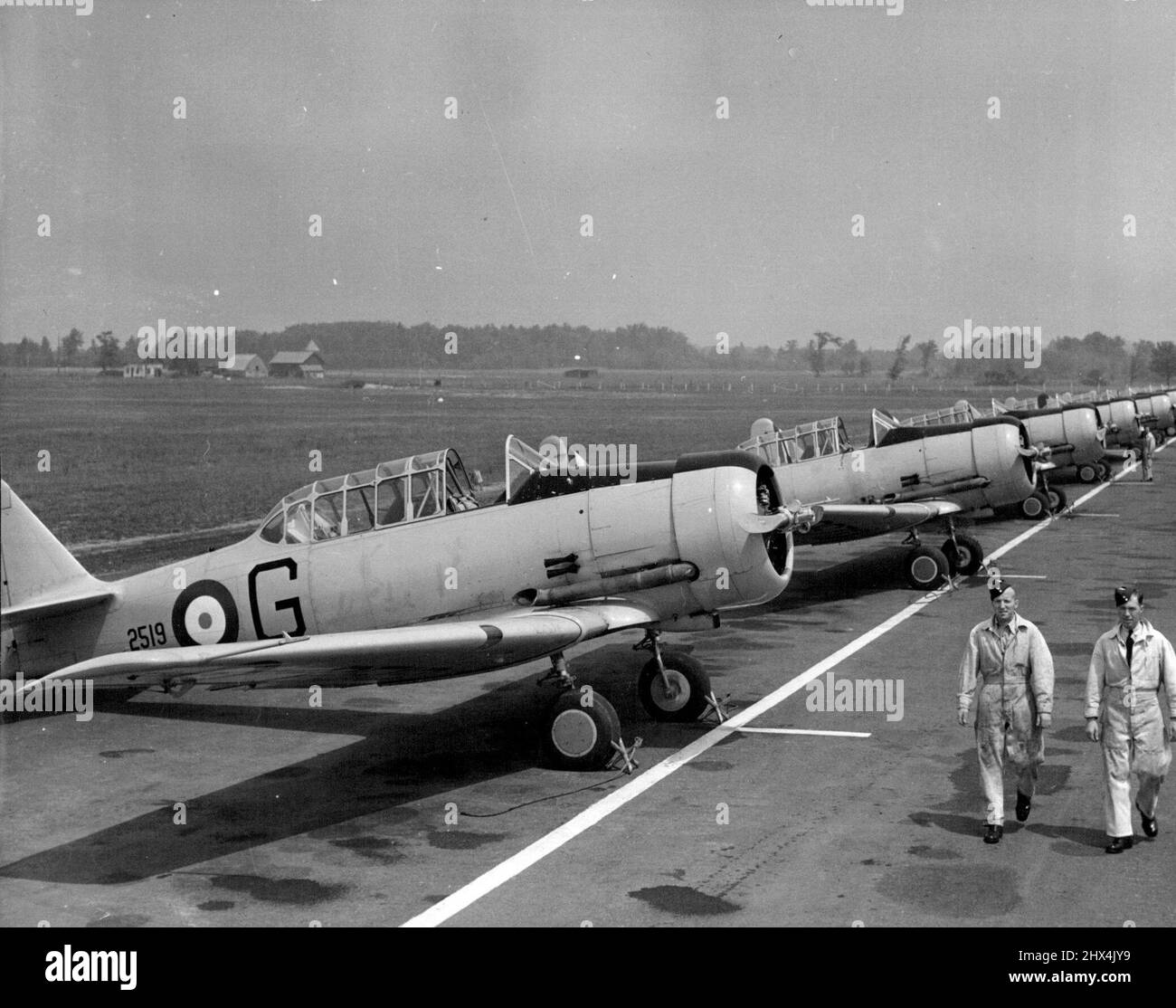Royal Canadian Air Force -- les entraîneurs de Harvard à l'aéroport d'Uplands, à Ottawa, se tiennent à côté pour l'entraînement quotidien des avions de combat Empire. 15 décembre 1941. Banque D'Images