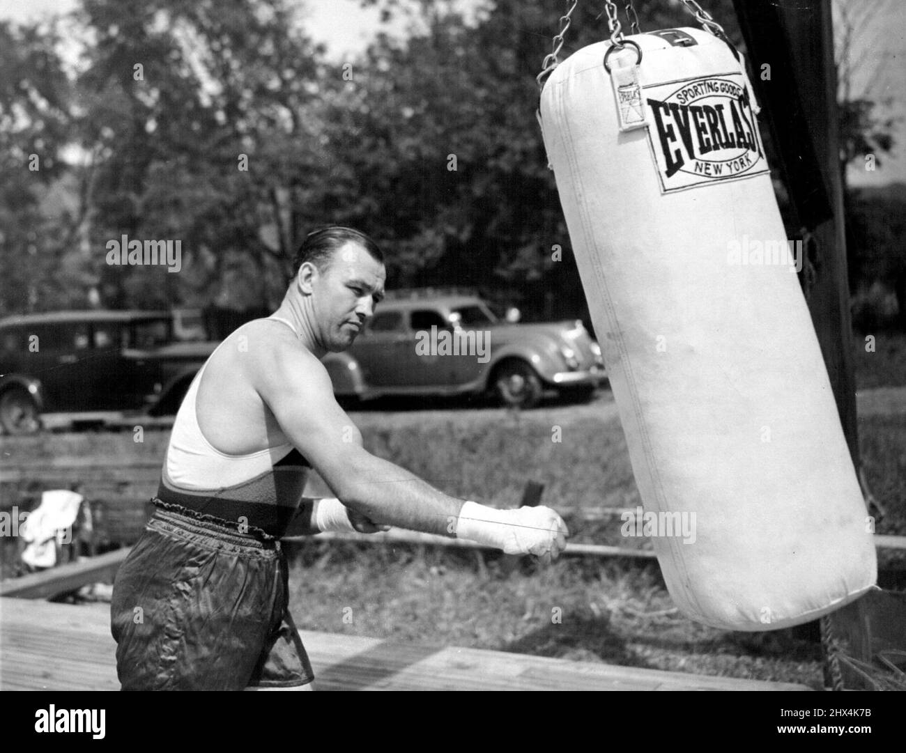 Les poinçons de Sharkey le sac Jack Sharkey a montré ici aujourd'hui qu'il a poinçonné le sac de sable lourd dans son camp d'entraînement alors qu'il a commencé ses entraînements préparatoires à son combat de poids lourd avec Joe Louis. 17 février 1953. (Photo par photo de presse associée). Banque D'Images