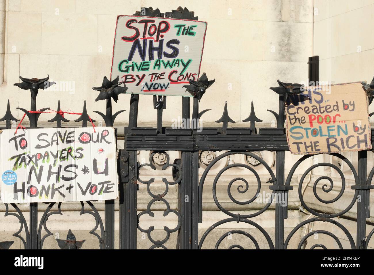 Les femmes protestataires se tiennent avec des signes- Save the NHS en dehors des cours royales de justice , Londres, Royaume-Uni Banque D'Images
