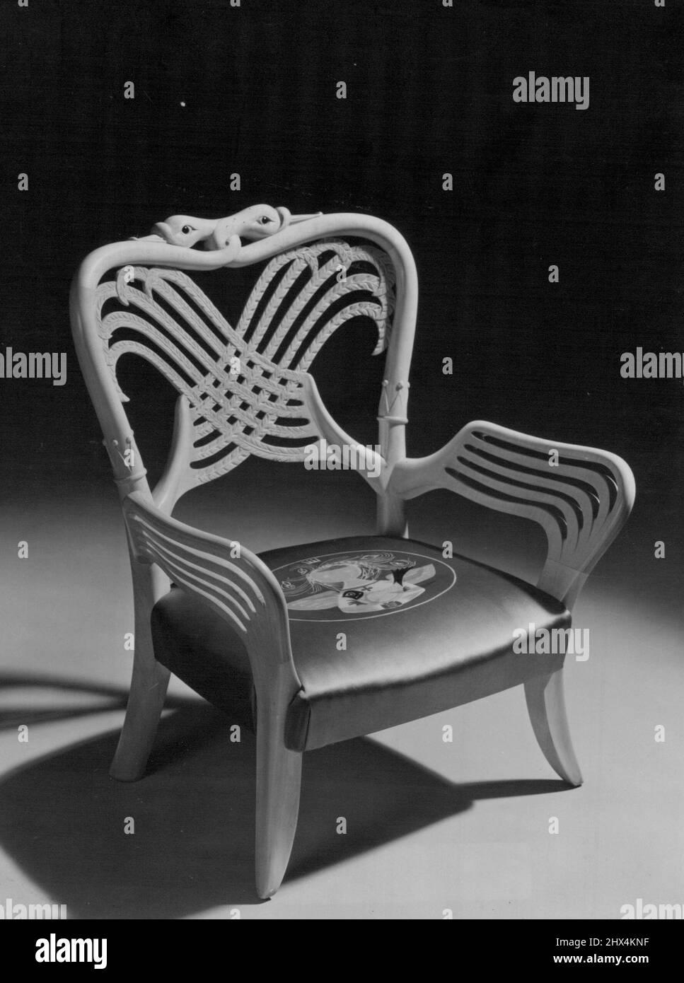 Une chaise digne d'Une princesse -- le cygne royal est le motif de cette jolie petite chaise, présentée à la princesse Anne par le Scottish Furniture manufactures, Limited, Et accepté par la Reine lors de son récent séjour à Holyrood. La chaise a été conçue par Basil Spence, l'architecte responsable de la conception de la nouvelle cathédrale de Coventry, Et est fait en Sycamore.grenats naturels forment les yeux des cygnes, dont les ailes entrelacées forment le dos et les bras de la chaise, chaque oiseau a une couronne autour de son cou.les ailes sont sculptées en contreplaqué laminé, donnant la force mais conservant la délicatesse et les lumières Banque D'Images
