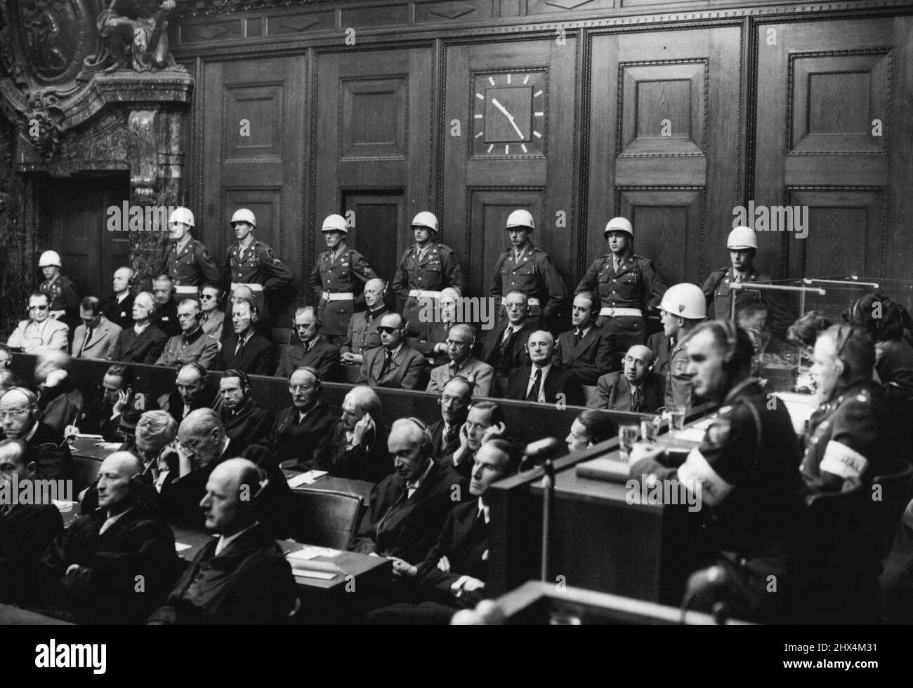 C'était la scène le jour du Reckoning -- ce jugement historique de Nuremberg, rendu hier par des juges britanniques, français, américains et russes, a décidé "que certains des accusés ont planifié et mené une guerre agressive contre les nations de l'is et ont donc été ***** de cette série de crimes". Les 21 anciens dirigeants de l'Allemagne nazie entendront leur culpabilité individuelle et les peines qui seront prononcées aujourd'hui. Avec leur conseil devant eux et les gardes des États-unis à l'arrière, les accusés écoutent la justice Lawrence à Nuremberg. 1 octobre 1946. Banque D'Images