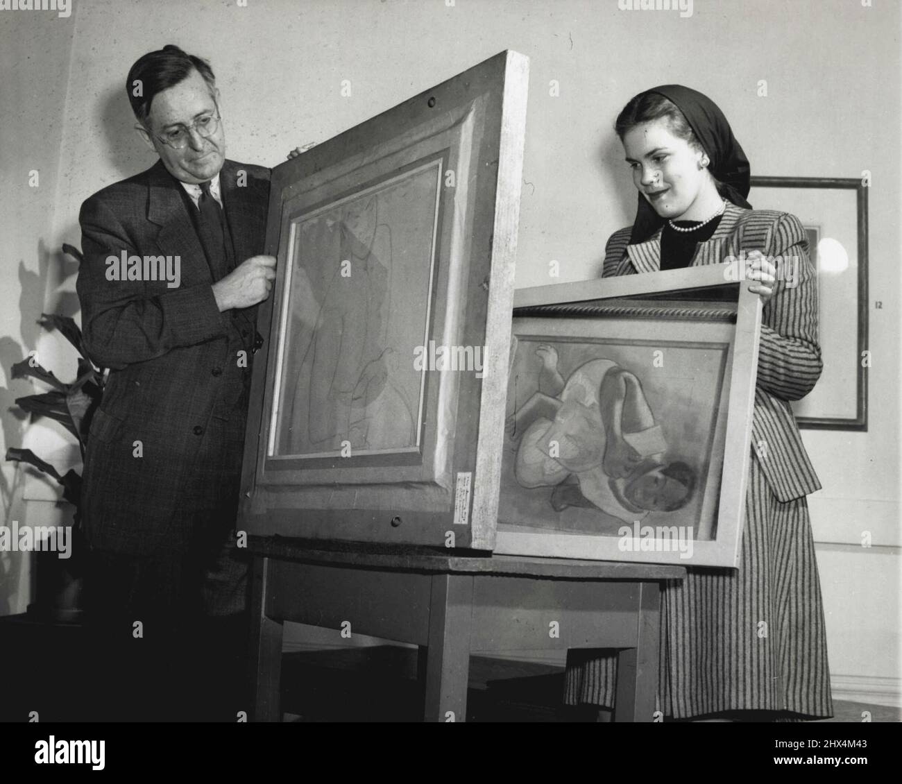 Trésor caché -- le détective d'art Carl O. Schniewind, conservateur des estampes et des dessins à l'Institut d'art ici, a récemment découvert un dessin de charbon de bois précieux sur le dos d'une impression de pastel qu'il préparait pour la collection permanente de dessins à montrer dans une exposition d'institut. Contribué par le fonds Tiffany Blake, le travail a été réalisé par Paul Gauguin, artiste français qui a vécu de 1848 à 1903, dont le pastel, femme tahitienne, est sur le côté de l'exposition. Ici, Schniewind voit le dessin de charbon de bois qu'il a trouvé tandis qu'Alice Baughton d'Olean, N.Y., étudiant à l'instutite, tient un miroir à Banque D'Images