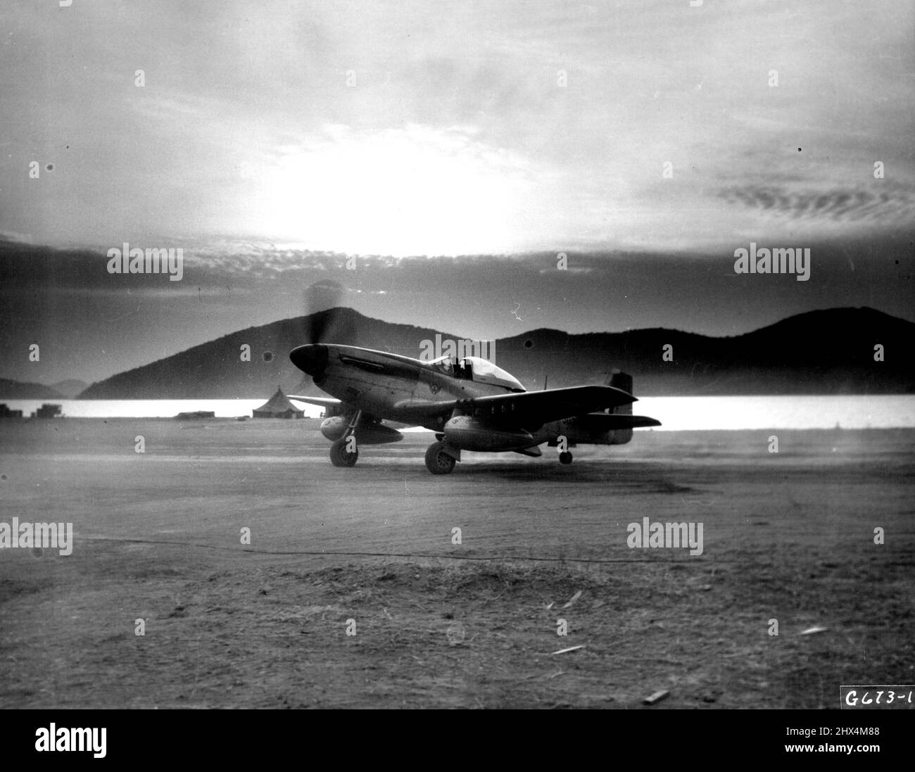 « By Dawn's Early Light » le lever du soleil sur les collines et l'eau de la Corée constitue un cadre pittoresque pour cette mustang F-51 de l'Armée de l'air sud-africaine, qui est son pilote « taxi » jusqu'à la fin de la piste pour un décollage à l'aube en soutien aux forces terrestres de l'ONU. Les Cheetahs sont les bienvenus des forces aériennes américaines de l'extrême-Orient dans le maintien de la suprématie aérienne en Corée. 19 mars 1951. (Photo de S.A. Air Force photo). Banque D'Images