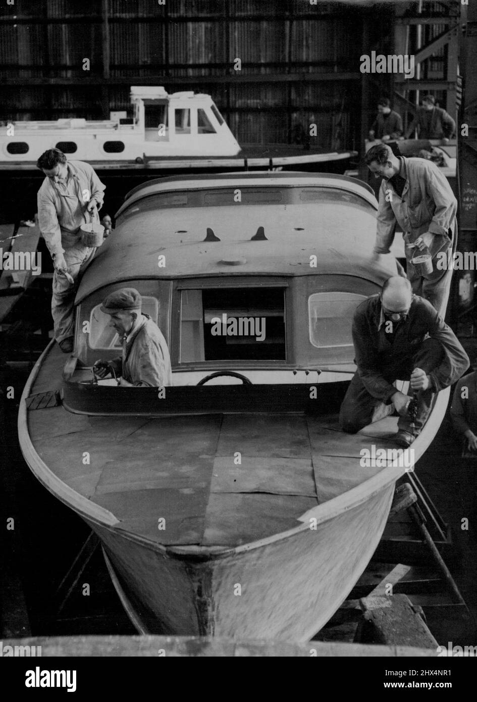 La barge royale du Britannia est prête pour le Coronation Review: Artisans travaillant sur la barge royale du chantier naval de Portsmouth. La barge royale du nouveau yacht royal Britannia (lancé récemment par la Reine sur Clydeside) est en cours de préparation au chantier naval de Portsmouth. La barge, construite par un film de Portsmouth en 1938, est dépouillée, repeinte et remouillée par un groupe d'artisans qualifiés dans le grand hangar à bateaux du chantier naval. Avant que la barge 'rejoint' le Britannia, elle sera présente sur H.M.S. Surprise (le navire de répartition devant être utilisé par la Reine et le duc d'Édimbourg) pendant le Coronati Banque D'Images