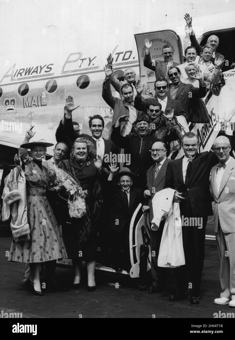 Spike Jones (deuxième à partir de la droite, en face) et ses « City Slickers », tous pris pour la grande ville, sont présentés à leur arrivée à l'aéroport de Sydney pour leur saison australienne. Ils ont été accueillis à l'aéroport par le commentateur de radio populaire Jack Dave (extrême droite). 29 mars 1955. Banque D'Images