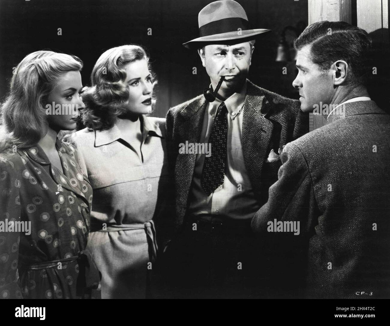 Tough Talk -- Paul Kelly (à droite) se coupe dans une conversation pour révéler quelques faits intéressants dans le drame de la radio RKO, 'Crossfire'. Les trois auditeurs sont (de gauche à droite) Gloria Grahame, Jacqueline White et Robert Young. 1 octobre 1947. Banque D'Images