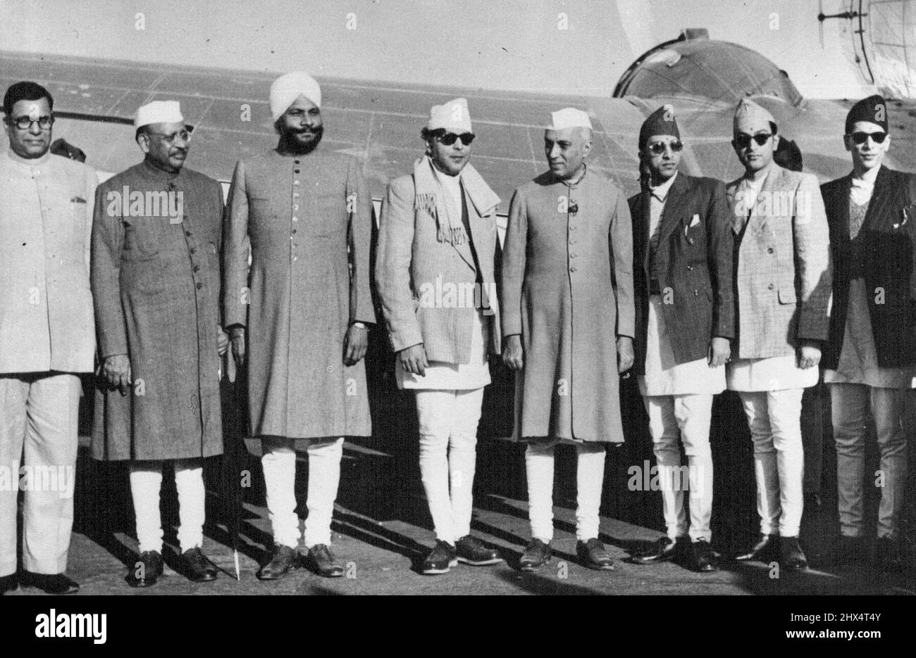 Le roi déchu du Népal prend refuge en Inde : l'honorable Shri H.K. Mehtab, Indian min, of Supply; Shri Sri Prakasa, min. Of Commerce; Sardar Baldev Singh, ministre de la Défense; le roi Tribhuvana du Népal; Pandit Nehru; le prince héritier du Népal et ses deux frères, à l'aéroport de Palam, à New Delhi. Le roi Tribhuvana, destitué par le Conseil népalais, s'est réfugié en Inde. Accompagné de membres de sa famille, il a été reçu à l'aéroport de Palam de New Delhi par Pandit Nehru, Premier ministre de l'Inde. 18 novembre 1950. (Photo par Sports & General Press Agency, Limited). Banque D'Images