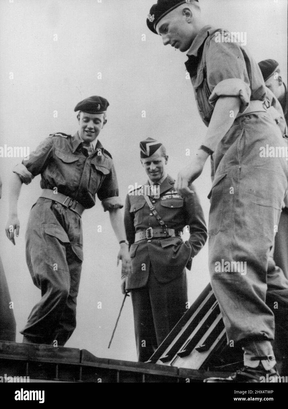 Le duc d'Édimbourg en Allemagne -- le duc d'Édimbourg - portant le chapeau vert et or du régiment, observant certains des hommes au travail pendant son inspection. H.R.H. le duc d'Édimbourg 1955, qui effectue une visite de quatre jours en Allemagne de l'Ouest, a passé une journée avec les 8th Royal Irish Hussars du roi, dont il est colonel en chef. 12 juillet 1955. (Photo de Sport & General Press Agency, Limited). Banque D'Images