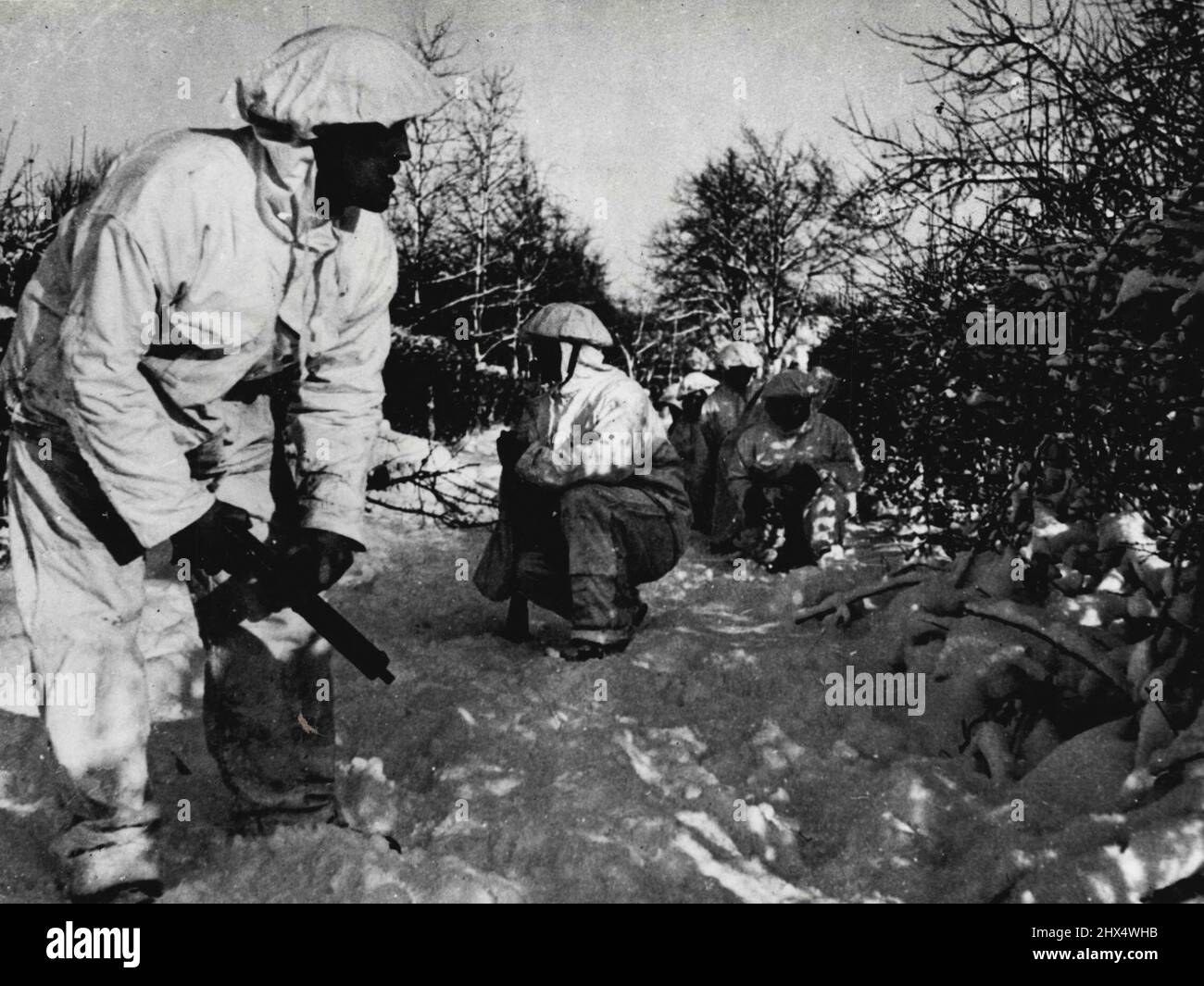 The White Patrol: Parti britannique 'Recce' en Allemagne -- voit partout que la patrouille fait son travail dangereux. C'est le genre de tableau que nous avons été habitués à associer au Front russe. Il a cependant été pris par un photographe de l'Armée accompagnant une patrouille britannique sur une patrouille de reconnaissance en Allemagne. Les troupes britanniques sur ce front et dans les Ardennes ont été émises avec des camouflons blancs, des fusils, des fusils, des radios, etc., tous sont enveloppés en blanc, avec le bon effet vu dans ce et les photographies d'accompagnement. 19 mars 1945. (Photo par British Official Photograph). Banque D'Images